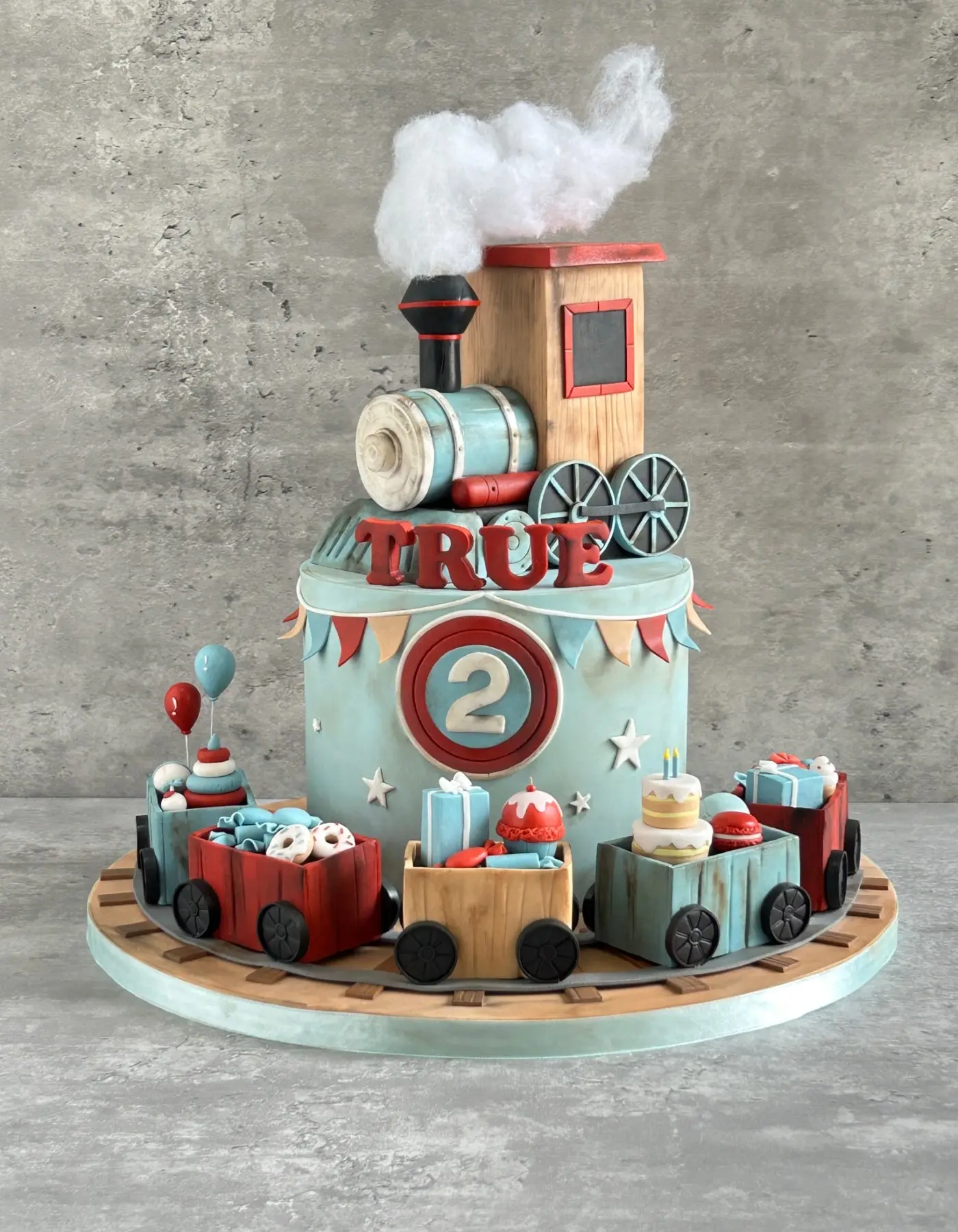 Steam train 2nd birthday cake with fondant carriages carrying sweets